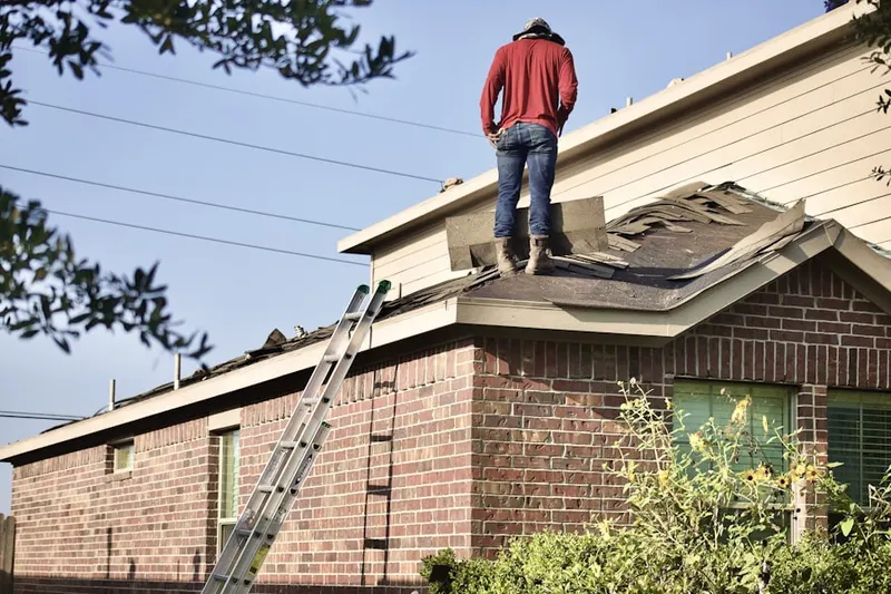 Professional roofer working on a residential roof in West Palmer Lake